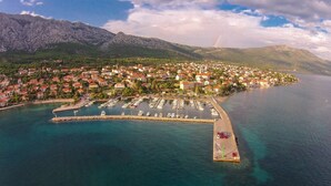 An aerial view of a coastal town with a marina, houses, and mountains in the background. - Great 3-Bedroom Apartment with Sea View (Orebic)