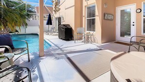 A poolside area with lounge chairs, a covered grill, and a ceiling fan. - 🏰 Disney Area 3BR Pool Home | Family-Friendly | Minutes to Golf & Attractions (Davenport)