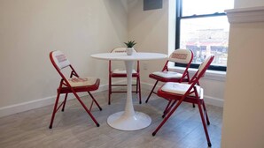 A room with a round table and four red chairs with white cushions. - Hoosier Suite Modern Studio Downtown on the Square (Bloomington)