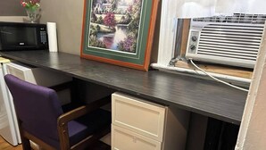 A kitchen with a microwave, a framed picture, a white cabinet, and a chair. - Maryland Homestay - Downtown Apartment #1 (Winnipeg)