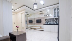 A modern kitchen with white cabinets, a black countertop, and a tiled backsplash. - The Boulevard Apartment By Abdihome (Jakarta)