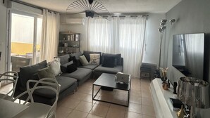 A modern living room with a sectional sofa, a coffee table, and a TV.
