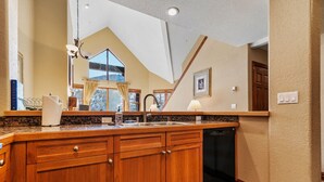 A kitchen with wooden cabinets, a granite countertop, a sink, and a dishwasher. - Entire condo in Avon, Colorado (Avon)
