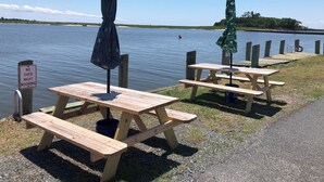 A lakeside picnic area with wooden tables and benches, a sign prohibiting overnight mooring, and a clear view of the lake. - Near Chincoteague & Assateague Island
Charming 2-bedroom cottage (Saxis)