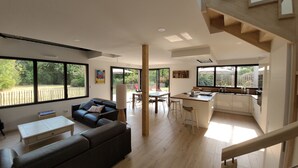 A modern living space with a dining area, kitchen, and a staircase. - Contemporary home in a quiet location, a 10-minute walk from the beaches (Loctudy)