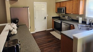 Una cocina compacta con armarios de madera, microondas, estufa y lavamanos.