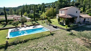 Ein Wohnhaus mit Swimmingpool, Terrasse und Garten.