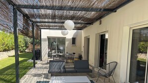 A covered patio area with a table and chairs, a sofa, and a pergola overhead. - Private pool villa in listed village, St Remy de Provence, les Alpilles.  (Saint-Rémy-de-Provence)