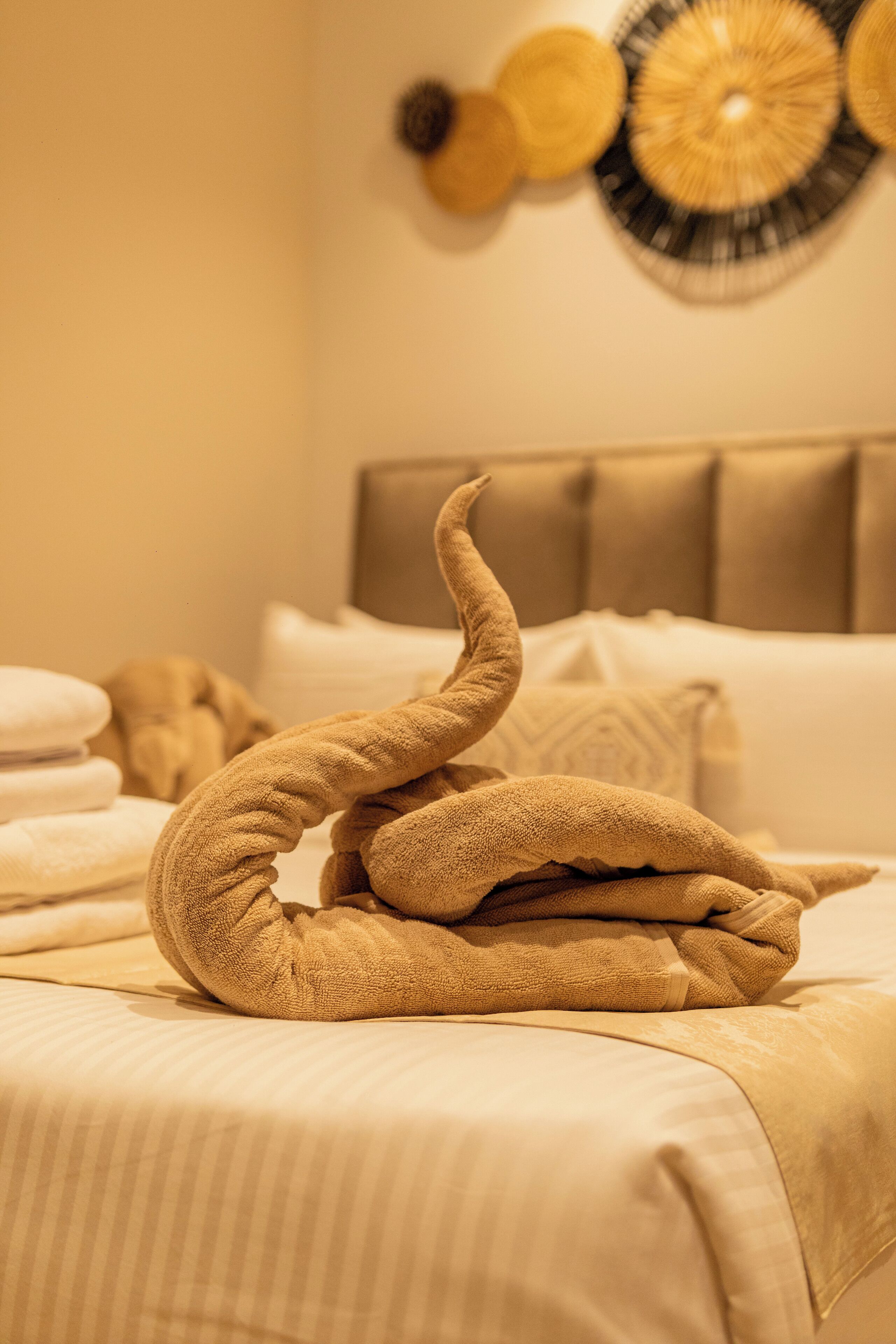 A neatly made bed with a decorative towel arrangement.