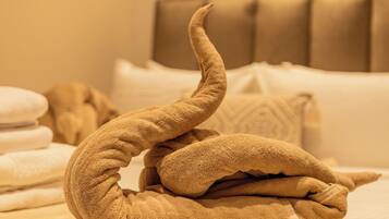 A neatly made bed with a decorative towel arrangement.