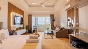 A modern hotel room with a large bed, a sofa, a coffee table, and a TV. - The newest Luxury at the heart of Negombo. (Negombo)