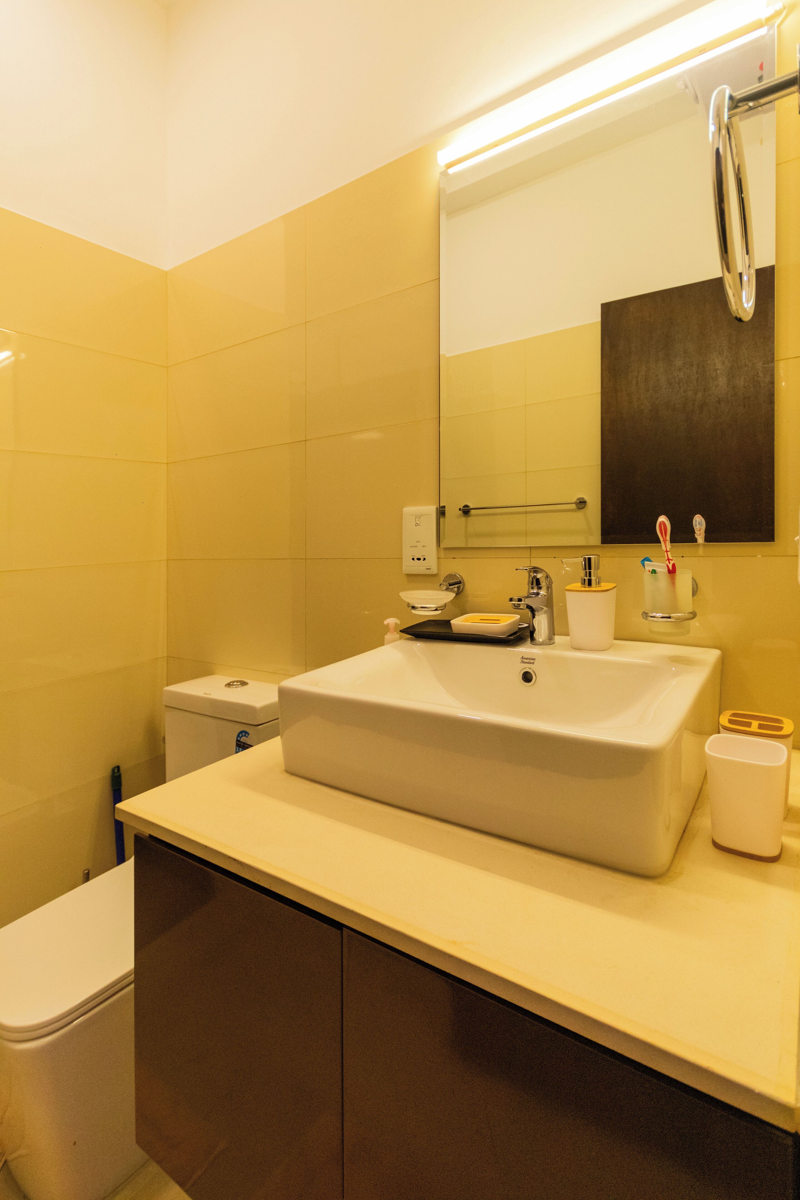 Ein modernes Badezimmer mit Waschbecken, Spiegel und Toilette.