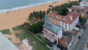 A coastal view with a beach, buildings, and a road. - The newest Luxury at the heart of Negombo. (Negombo)