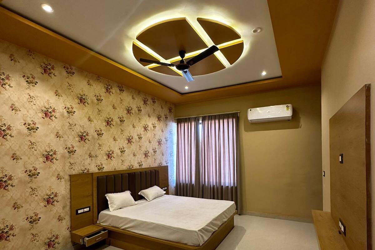 A modern bedroom with a large bed, a ceiling fan, and a built-in air conditioning unit.