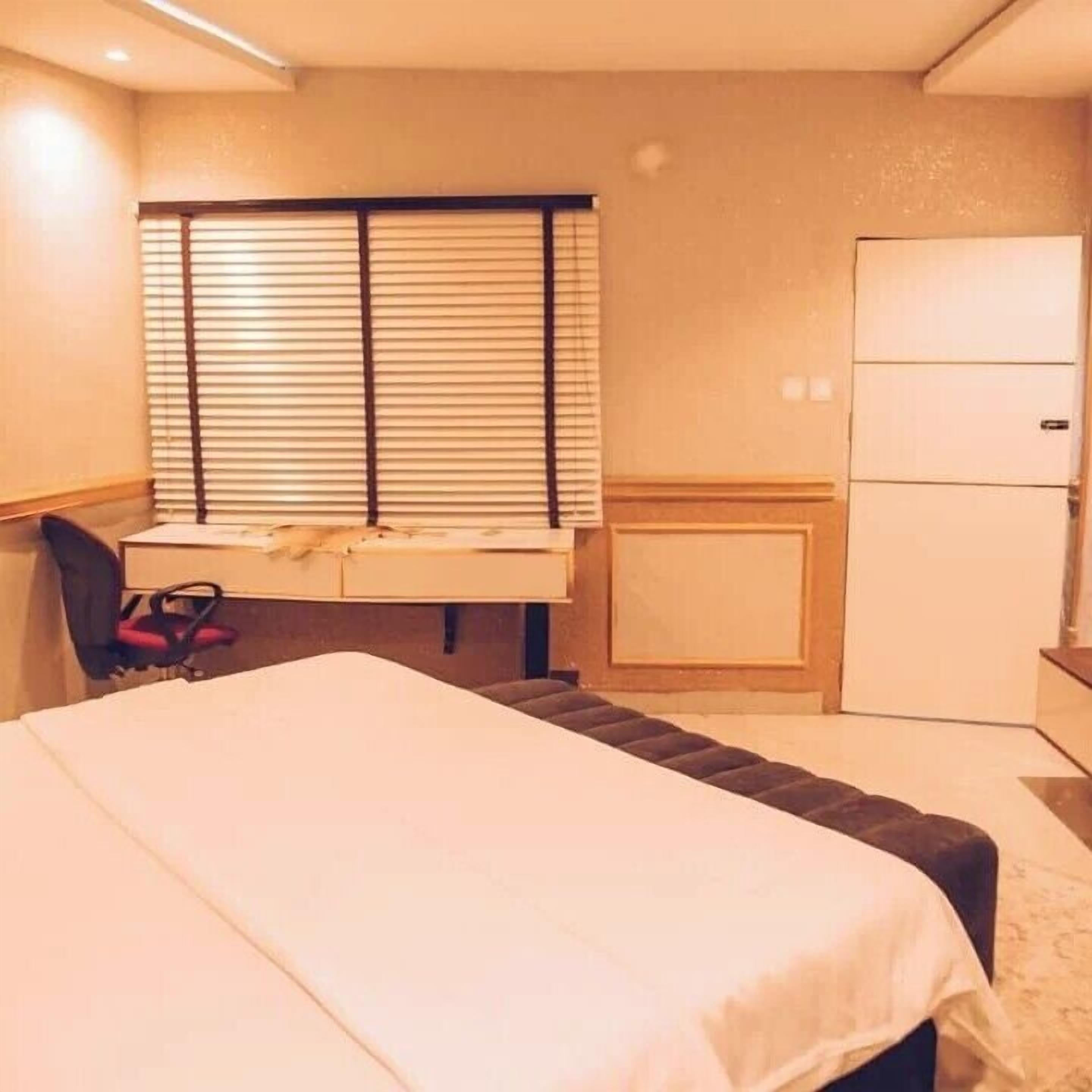 Un dormitorio con cama, escritorio, silla y armario.