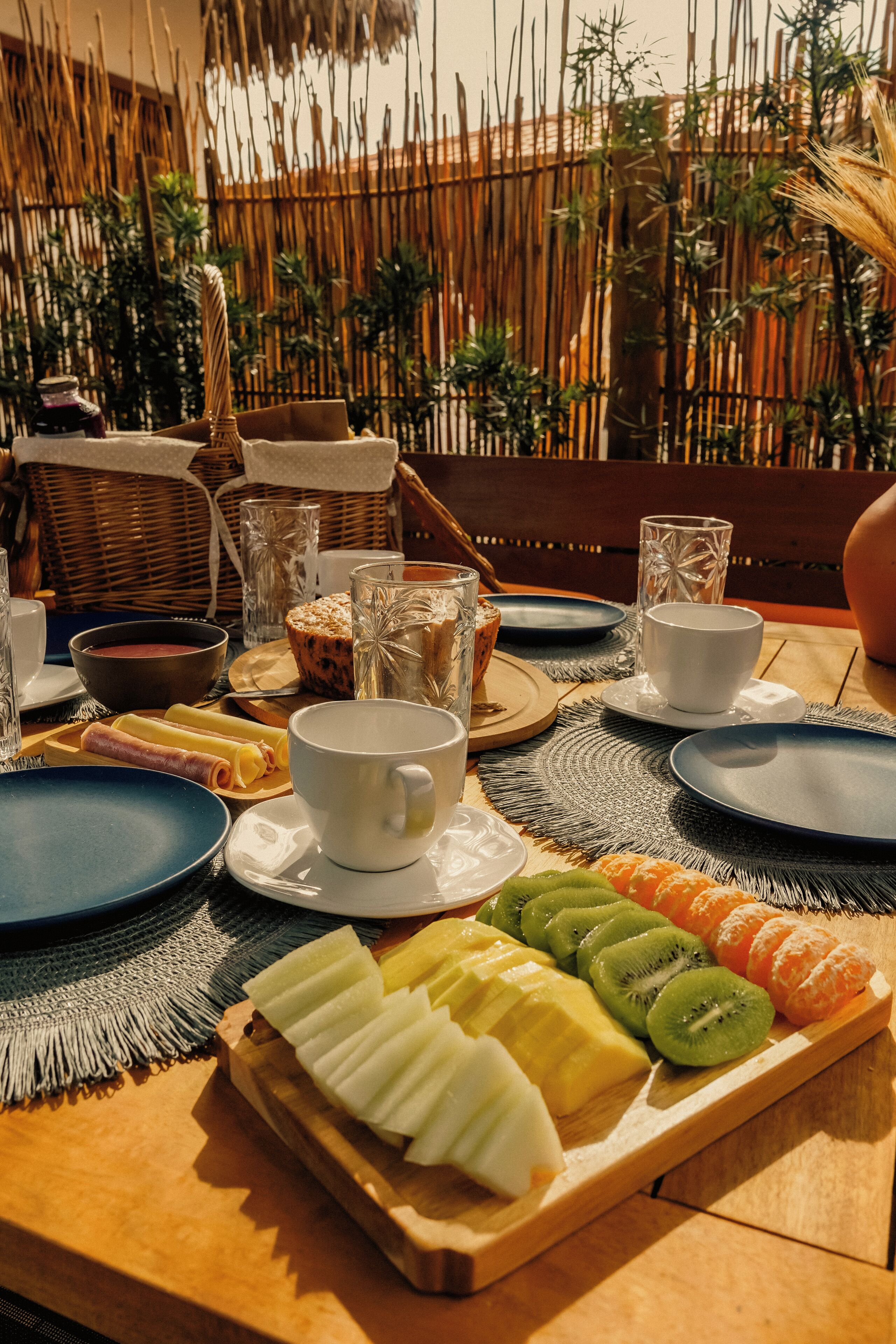 A table set with plates, bowls, cups, and a fruit tray.