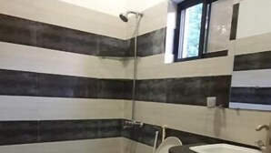 A bathroom with striped walls, a toilet, and a sink. - Infinity Villa (Islamabad)