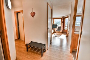 A hallway with wooden flooring, a small bench, and a heart-shaped decoration on the wall. - 8th floor, balcony, 48m², Les Gets (Les Gets)