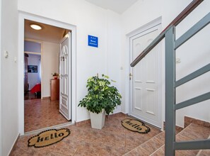 A hallway with a 'HELLO' mat, a potted plant, and a sign indicating an apartment. - Brigth and Breezy Rovinj Apartments (Rovinj)