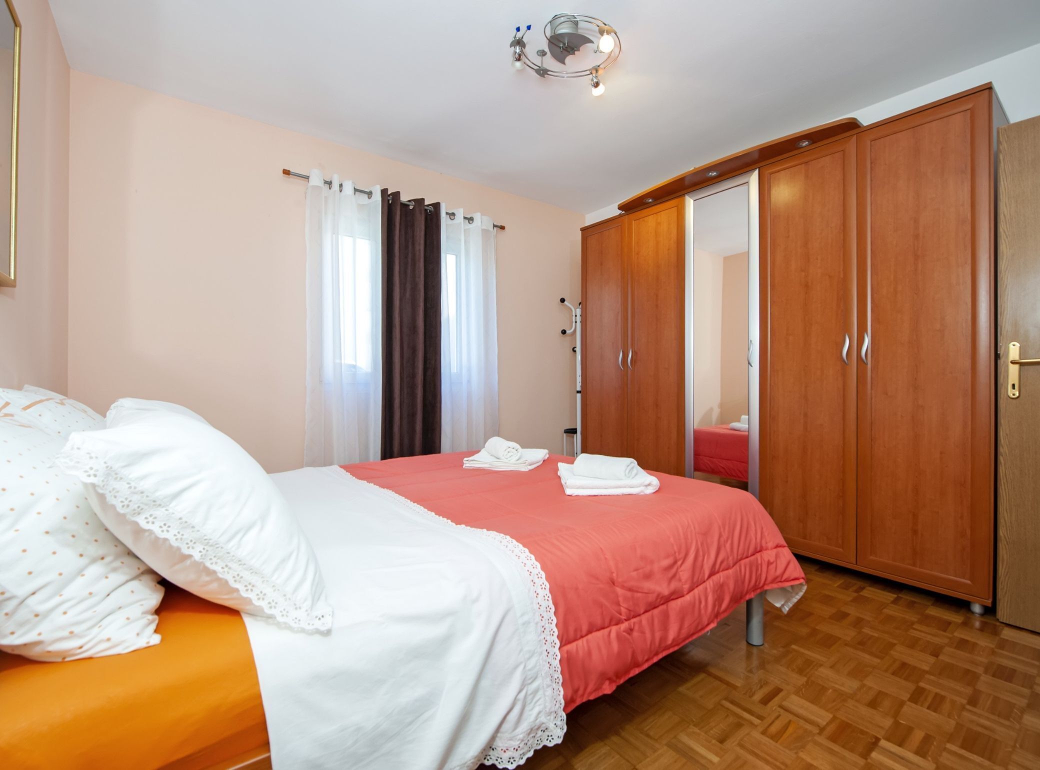 Une chambre à coucher avec un lit, une armoire et un miroir.