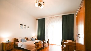 A bedroom with a wooden bed, a nightstand, a chair, and a wardrobe. - Green and Lush Apartments With Terrace (Rovinj)