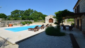 A pool area with lounge chairs, a stone building, and a pergola. - Majestic Rustical Kanfanar Villa With Pool (Kanfanar)