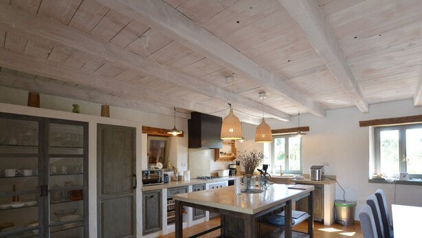 A spacious kitchen with wooden floors, a central island, and pendant lighting. - Majestic Rustical Kanfanar Villa With Pool (Kanfanar)