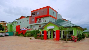 A hotel with multiple colorful buildings, a public bar and gift shop, and a paved courtyard.
