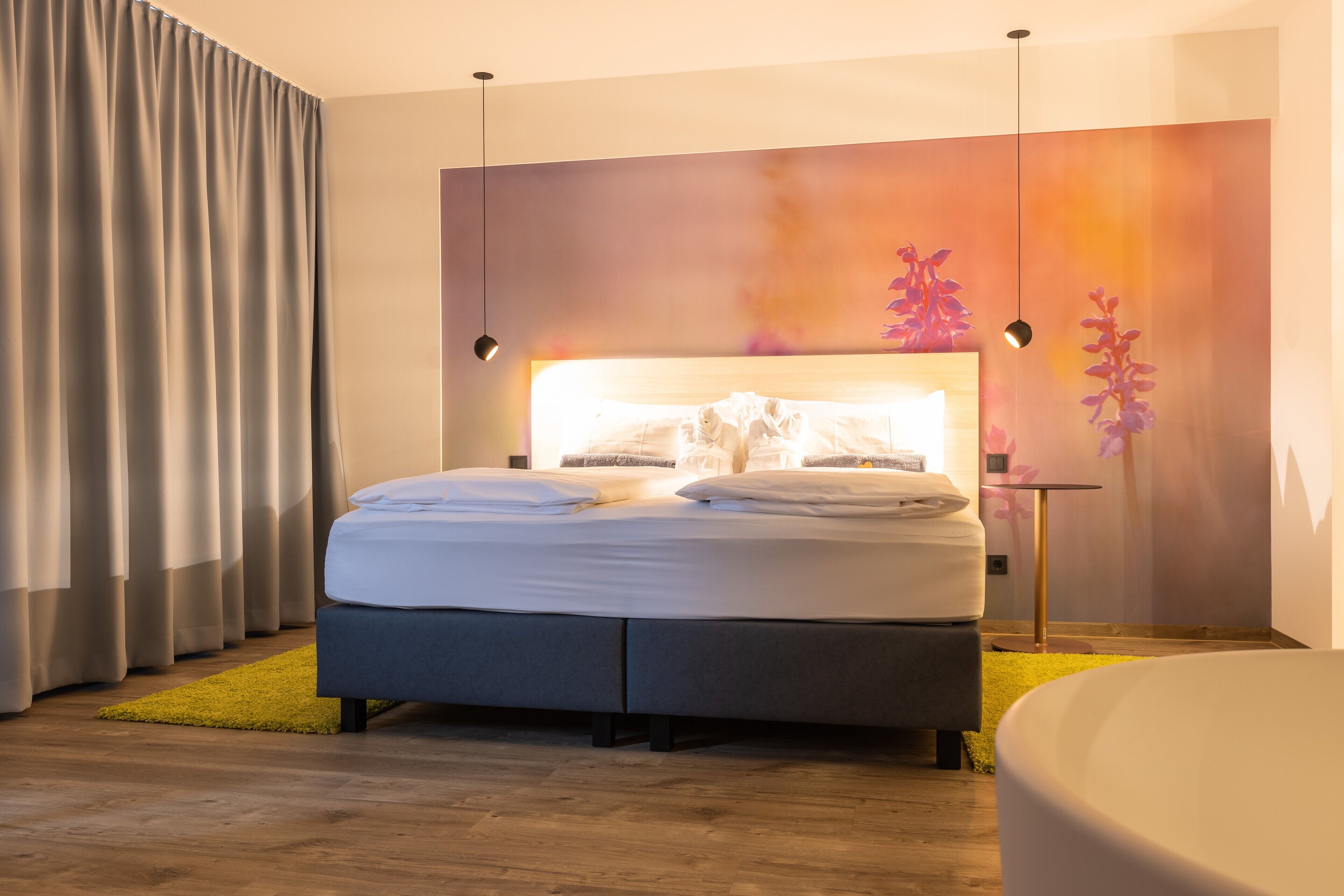 Ein modernes Schlafzimmer mit einem Bett, einem Nachttisch, einem Wandbild und einem gelben Teppich.