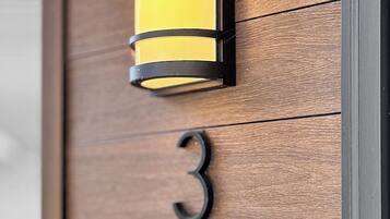 A wooden door with a number '3' and a wall-mounted light fixture.