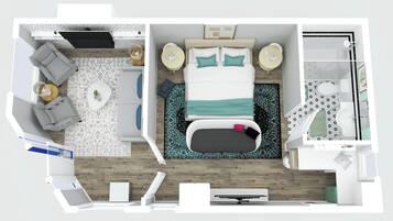 Quarto de hotel com cama, mesas de cabeceira, área de estar com sofá e poltronas, pequena mesa com abajur e banheiro com chuveiro e vaso sanitário.