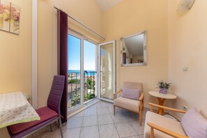 A balcony with a chair, a small table, and a sofa.