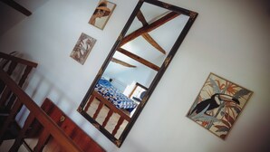 A room with a large mirror, wooden furniture, and artwork on the walls.