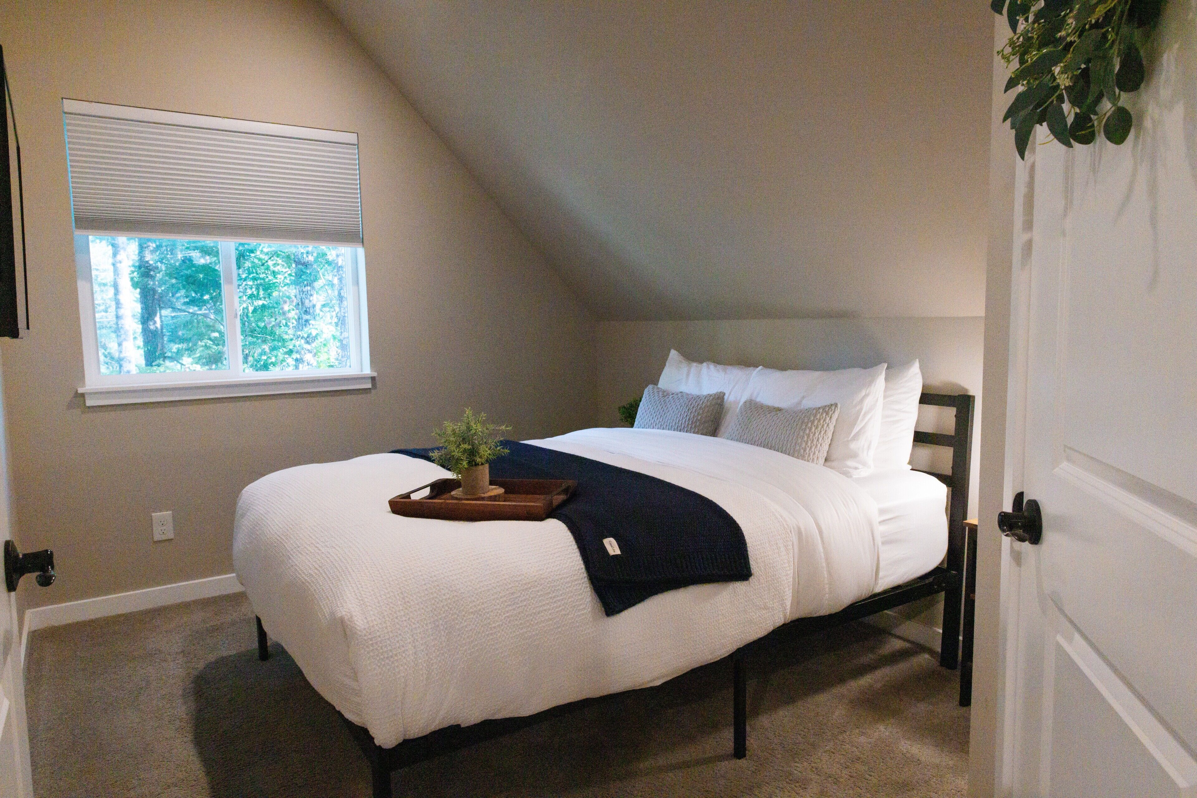 Une chambre à coucher avec un lit, une fenêtre et une porte.