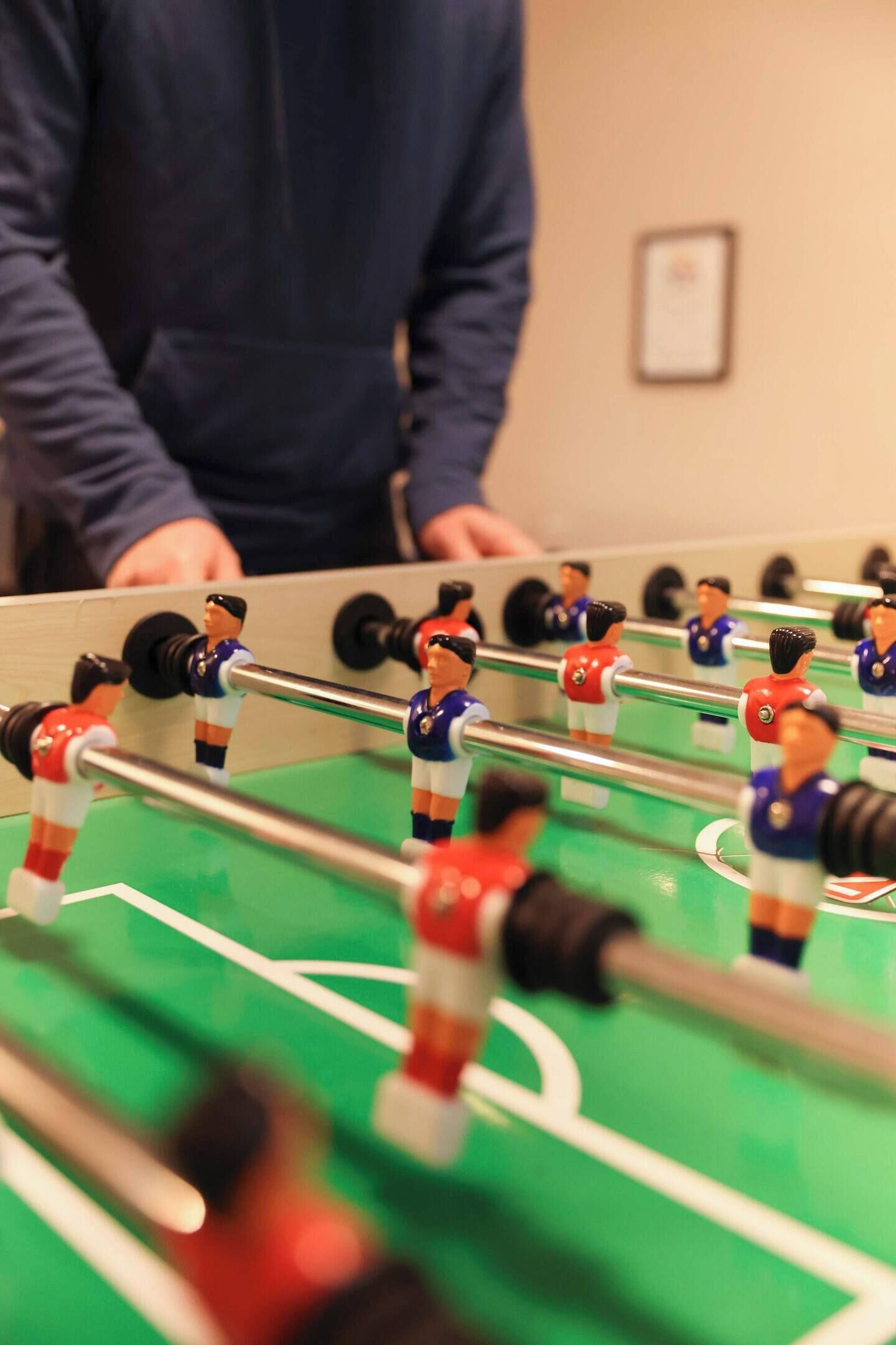 A foosball table with players in red and blue uniforms.