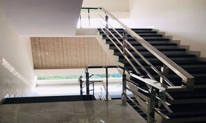A modern staircase with metal railings and a geometric patterned wall in the background. - Hotel Atharv Inn (Indore)