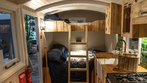 A compact, wooden interior with a bunk bed, a ladder, a kitchenette, and a window. - If you go into the woods today... Off-grid yet comfy, warm and luxurious  (Canterbury)