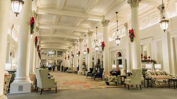 A spacious lobby with high ceilings, large columns, and chandeliers.