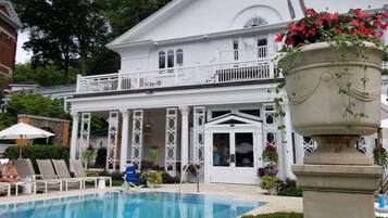 A pool area with lounge chairs and a large planter with flowers.