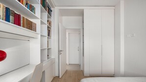 A bedroom with a bed, a desk, a chair, a bookshelf, and a wardrobe.