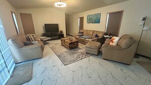 A living room with a sofa set, a television, a wooden chest, and a patterned rug. - Spacious Peaceful 2-bedroom home in Saint Ignatius, Montana with amazing views. (Saint Ignatius)