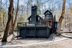 A cabin with a large deck, a chimney, and a satellite dish. - Riverfront Cabin in Coosawatte with Playset (Ellijay)