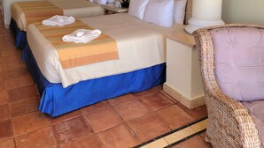 A hotel room with two beds, a large painting on the wall, a lamp, and a wicker chair. - Pueblo Bonito Rose Resort & Spa - Luxury 1-bedroom Suite, right on Medano Beach! (Cabo San Lucas)