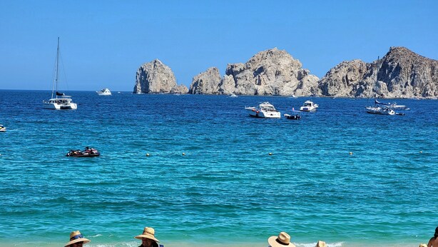 A beach with people, boats, and rocky cliffs in the background. - Pueblo Bonito Rose Resort & Spa - Luxury 1-bedroom Suite, right on Medano Beach! (Cabo San Lucas)