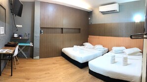 A hotel room with two beds, a desk, a TV, and an air conditioning unit. - Le Deon Hotel (Batu Gajah)