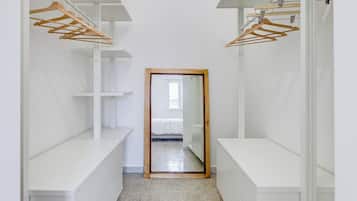 Ein schmaler Gang mit weißen Schließfächern an beiden Seiten und Holzaufhängern an der Decke.