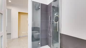 Ein modernes Badezimmer mit einer Duschkabine, einer Toilette und einem Waschbecken.