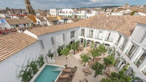 A courtyard with a swimming pool, outdoor seating, and a view of the surrounding buildings.