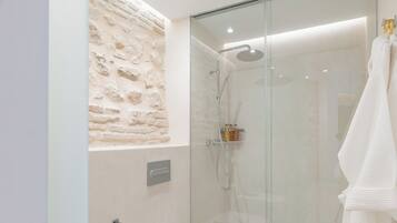 Un baño moderno con ducha envuelta en vidrio, inodoro y lavamanos.