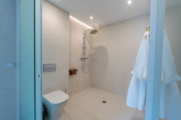 A modern bathroom with a shower, toilet, and towel rack. - Portería Santa Clara Hotel Boutique (Córdoba)